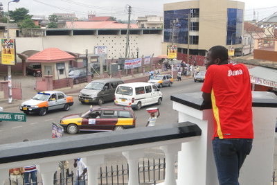 Man Watches Street Scene from Balcony of Barclay's Bank - Kumasi - Ghana, Kumasi, 2010