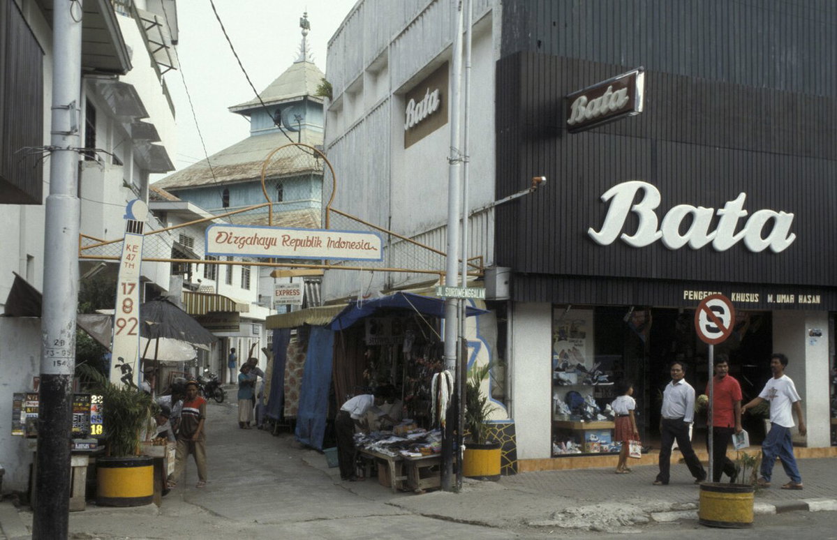 Collectie NMvWereldculturen, TM- , Dia- Java, Semarang Toegangsweg naar stadskampong; op de achtergrond dak van de moskee. Rechts op de voorgrond bord met opschrift, Semarang, Indonesia, 1993