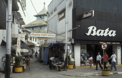 Collectie NMvWereldculturen, TM- , Dia- Java, Semarang Toegangsweg naar stadskampong; op de achtergrond dak van de moskee. Rechts op de voorgrond bord met opschrift, Semarang, 1993
