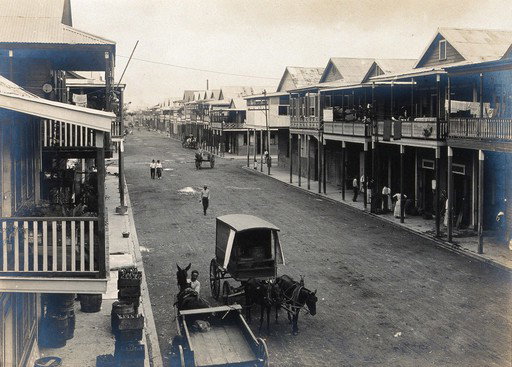 EU: Colón, Panama: tarmacadamed street with storm sewer; residents shown in houses and on the street, with horse and cart in the foreground. Photograph, (1911), Colón, Panama, 1911