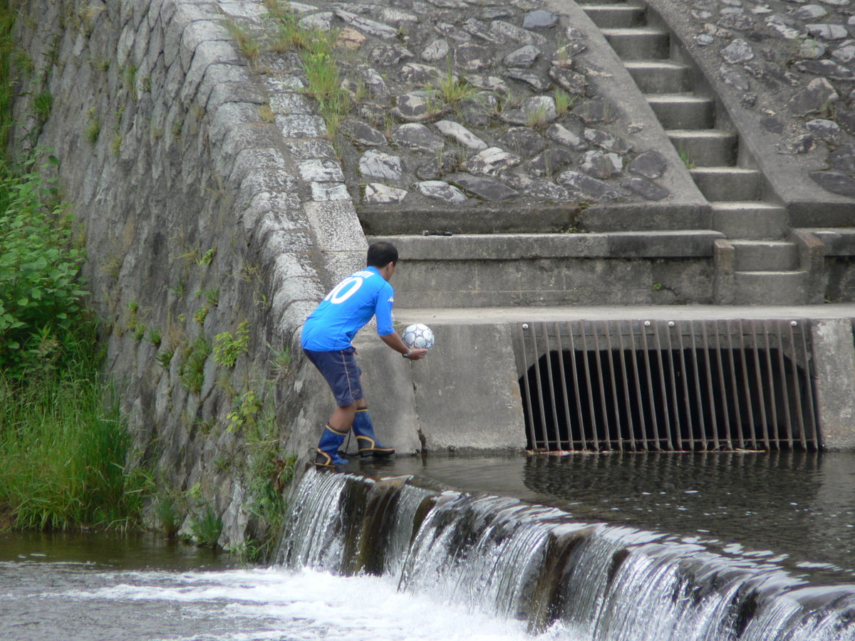 Retrieving a soccer ball from the Kamo River (Kamogawa), Kyoto, Japan, 2007