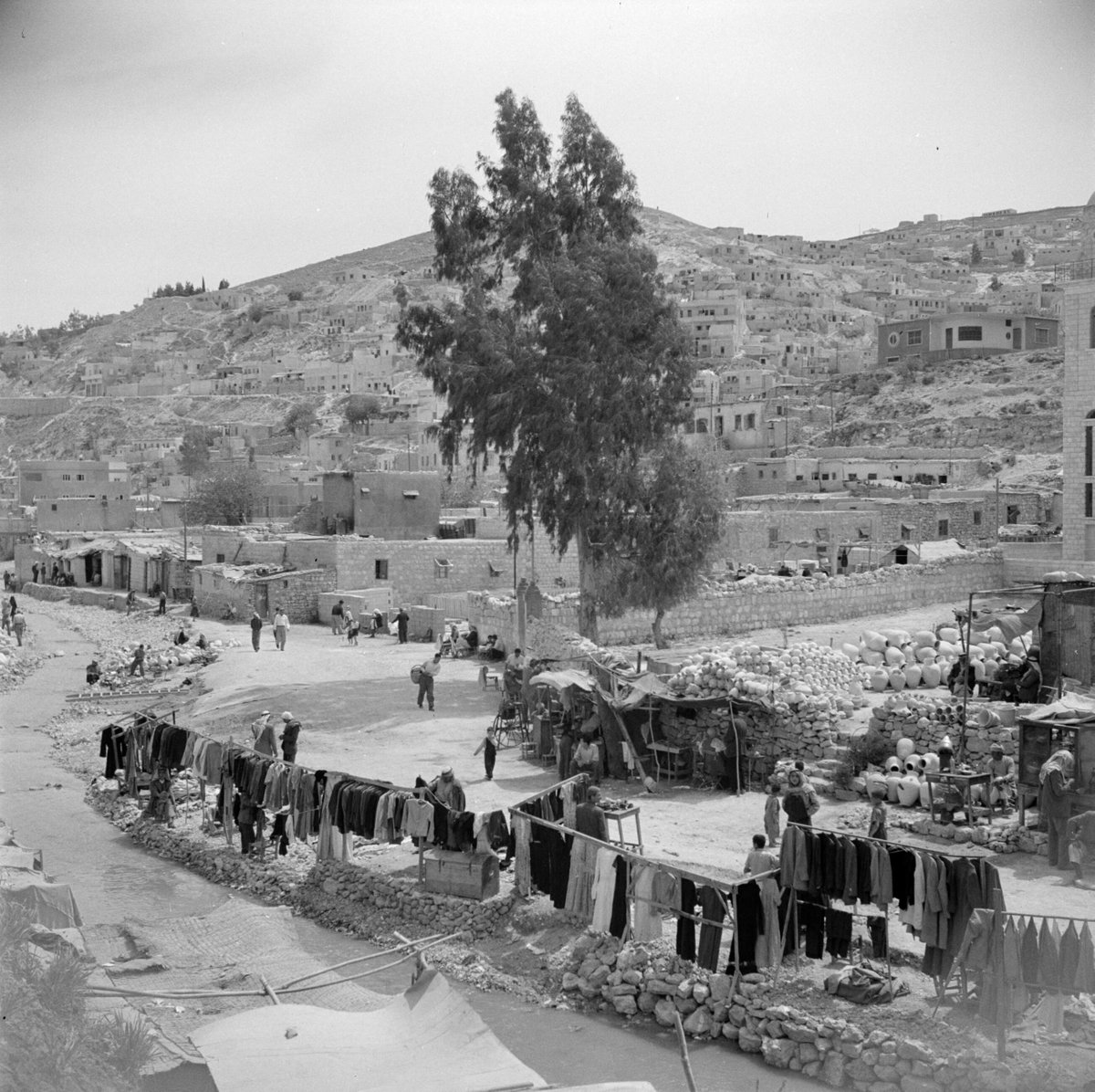 EU: Overzicht van een kledingmarkt aan de rand van de stad Amman (1950) [1], Amman, Jordan, 1950