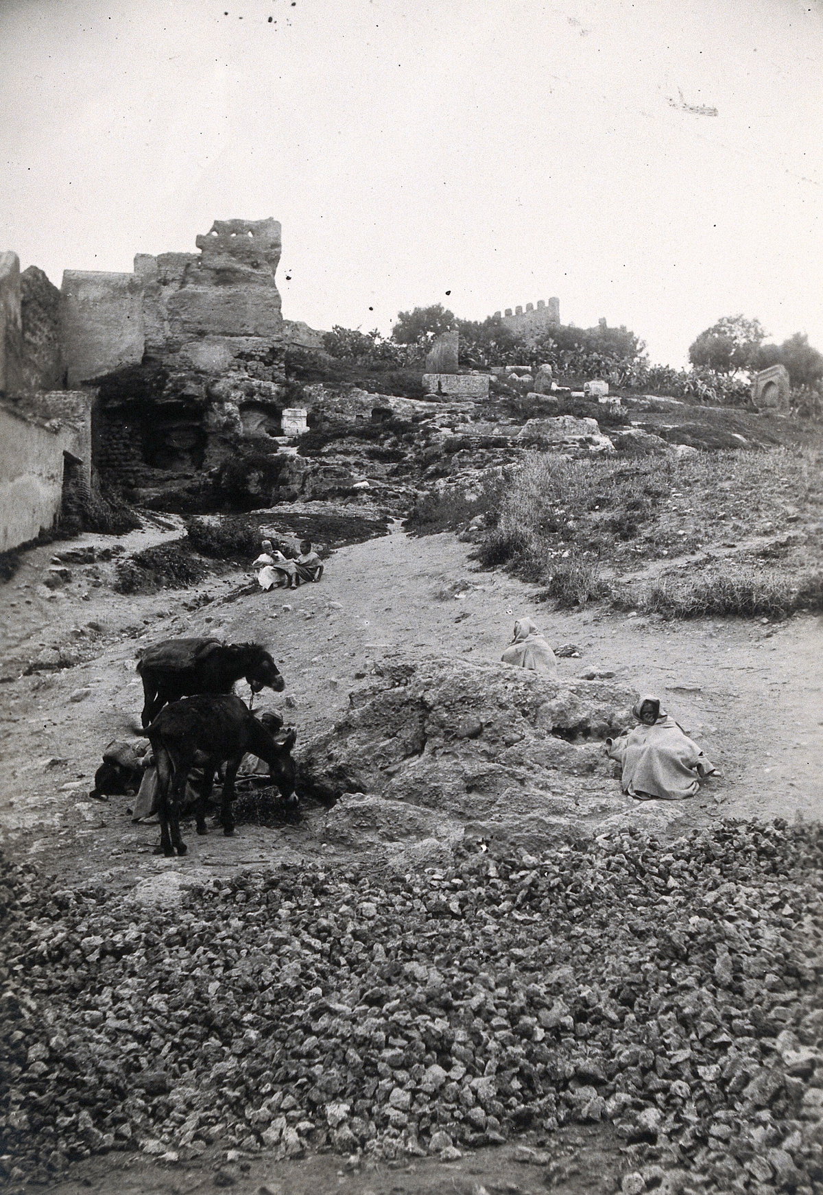 EU: Fez, Morocco: the path to Bab Ghissa with ruins in the background and donkeys and cloaked figures in the foreground. Photograph, (1922), Fes, Morocco, 1922
