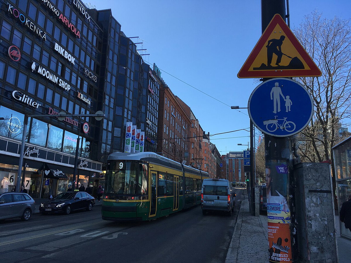 Retail building signs; tram; construction sign; bikes and pedestrians sign, Helsinki, Finland, 2018