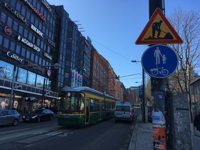 Retail building signs; tram; construction sign; bikes and pedestrians sign, Helsinki, 2018