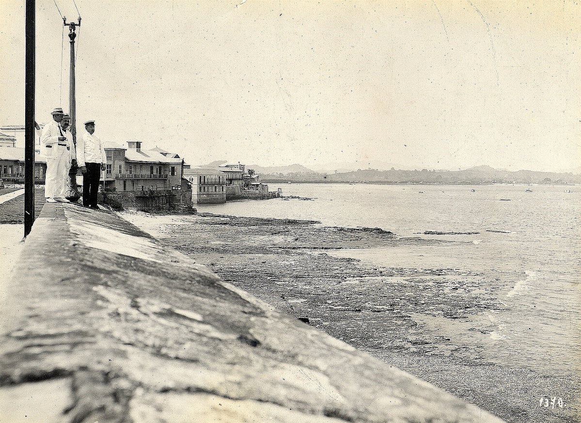 EU: Panama-Stadt (Panama). Drei Touristen stehen auf einer Mauer am Strand und blicken über die Bucht (1915), Panama City, Panama, 1915