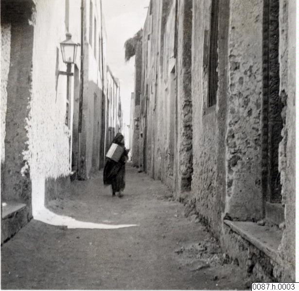 EU: Woman walking through alley, Lamu old town (1912), Lamu, Kenya, 1912