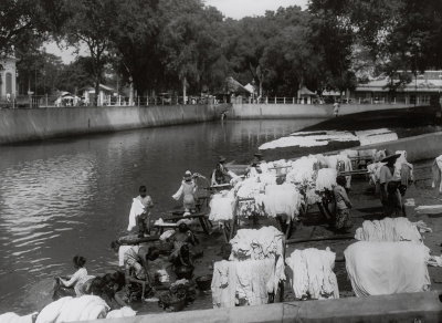 EU: Batavia (Jakarta), Indonesien. Glodok (Altstadt). Einheimische Frauen, Männer und Kinder beim Wäschewaschen am städtischen Kanal, daneben Trockengerüste und Uferfläche für Wäschebleiche (1912), Jakarta, 1912